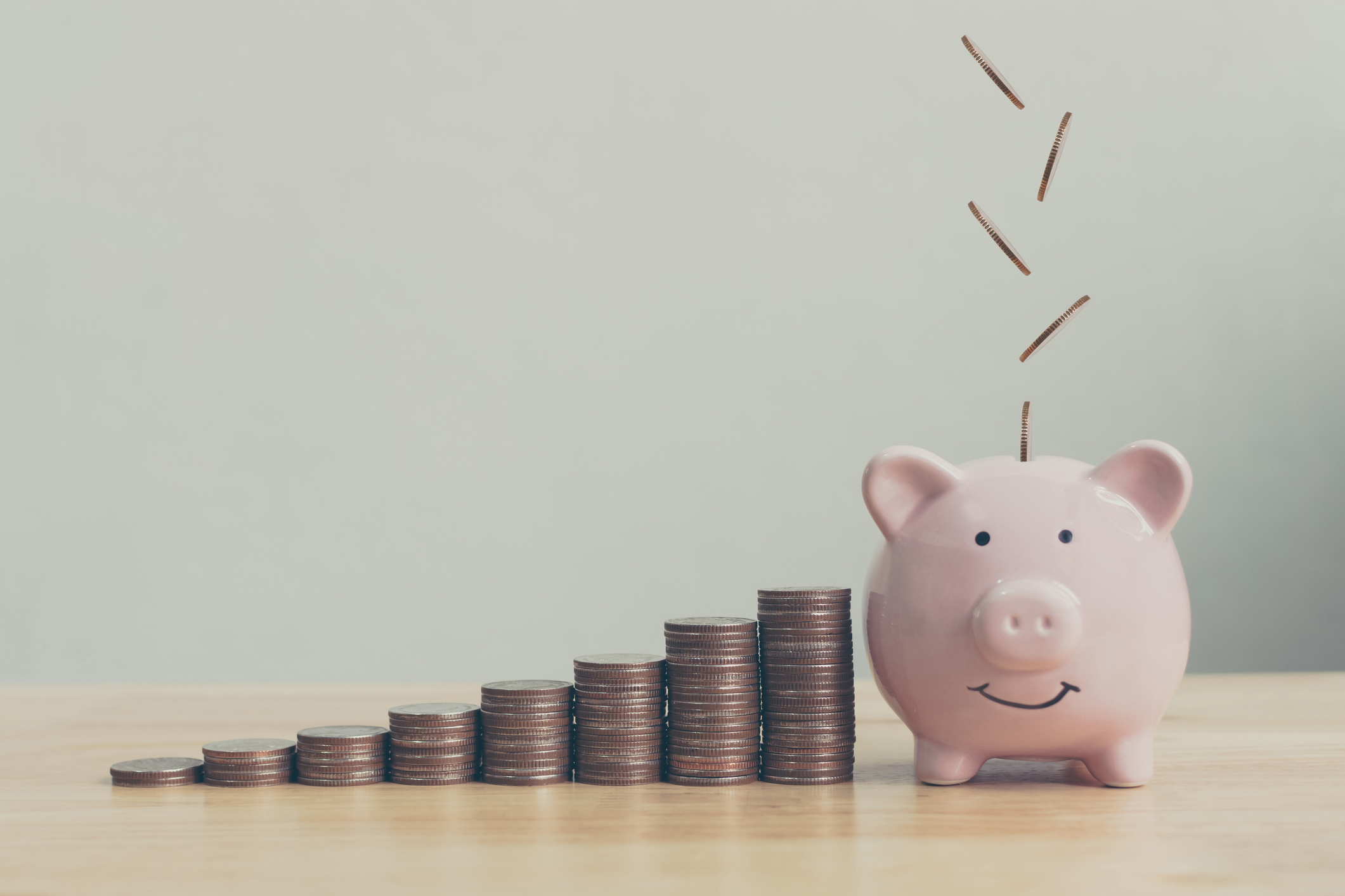 Coins stacked up beside a piggy bank